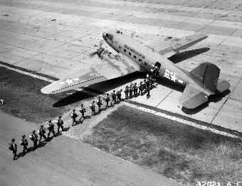 Dozens of combat-ready troops boarding a C-47